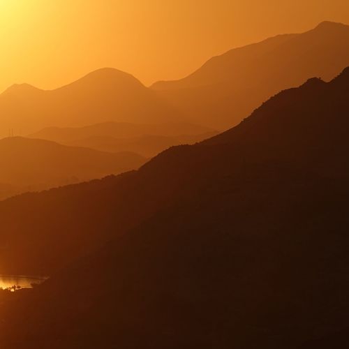Scenic view of silhouette mountains against sky during sunset