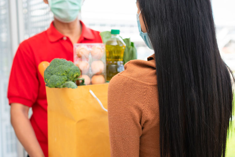 Midsection of woman receiving grocery at store