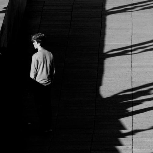 High angle view of man standing on steps during sunny day