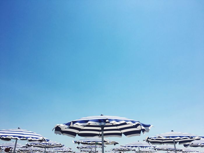 Beach umbrellas against clear blue sky
