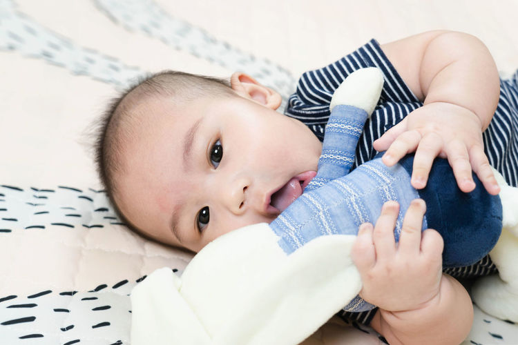 Portrait of cute baby lying on bed