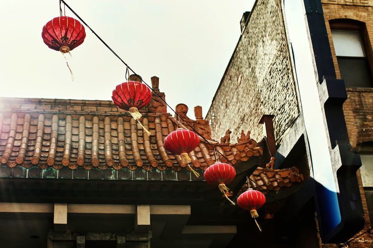 Low angle view of lanterns hanging on roof of building