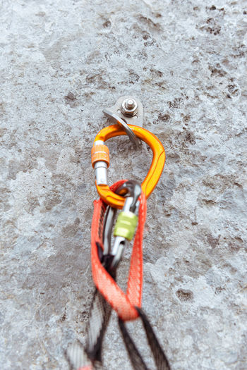 Orange carabiner with rope on rock