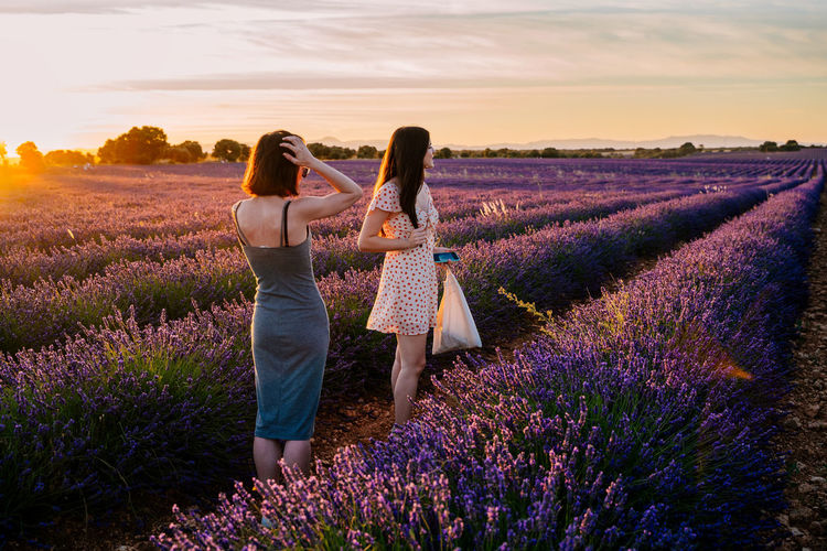 Full length of women standing on flower field