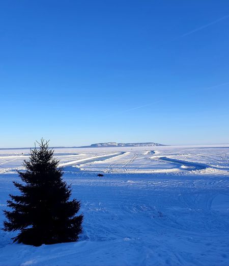Scenic view of snowcapped landscape against clear blue sky