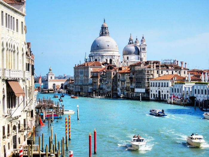 Boats in grand canal with santa maria della salute against sky