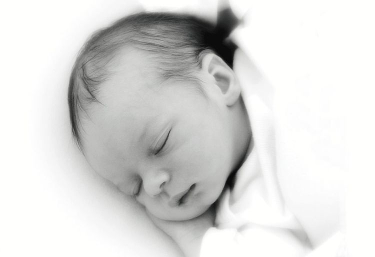 Close-up of cute baby sleeping on bed