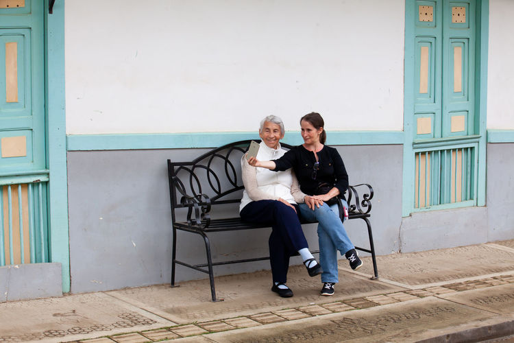 Senior mother and adult daughter traveling together at the small town of salento in colombia