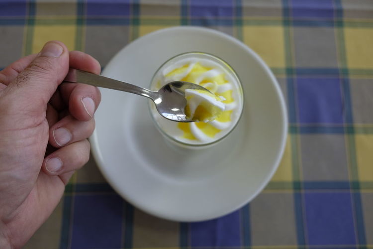 Cropped image of hand taking ice cream in spoon
