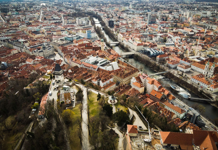 Aerial view from graz hill schlossberg in austria, cityscape with house roofs, mur river