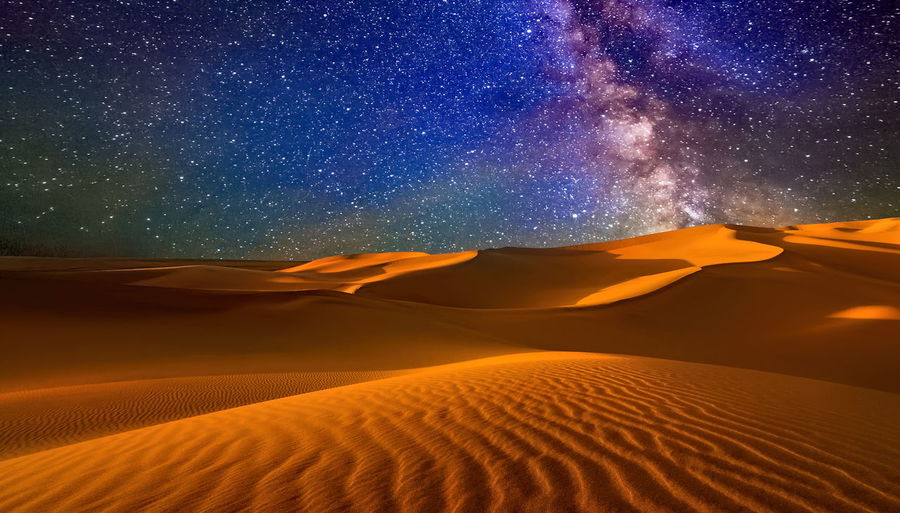 Sunset over the sand dunes in the desert. arid landscape of the sahara desert