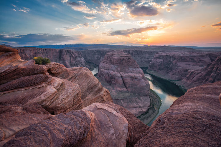 Scenic view of horseshoe bend against sky during sunset