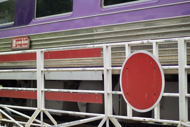 Close-up of metal barricade by train