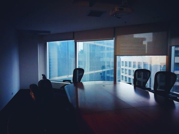 Empty conference table against window in office
