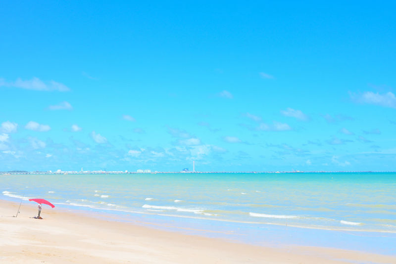 Scenic view of beach against blue sky