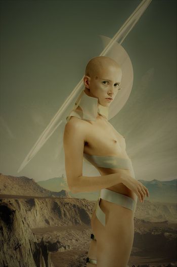 Portrait of naked alien standing against sky