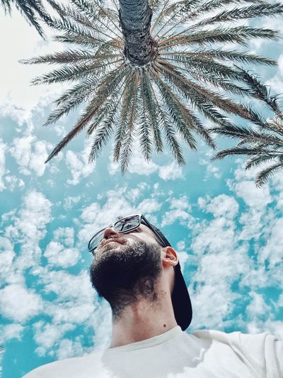 Portrait of young man wearing sunglasses against sky