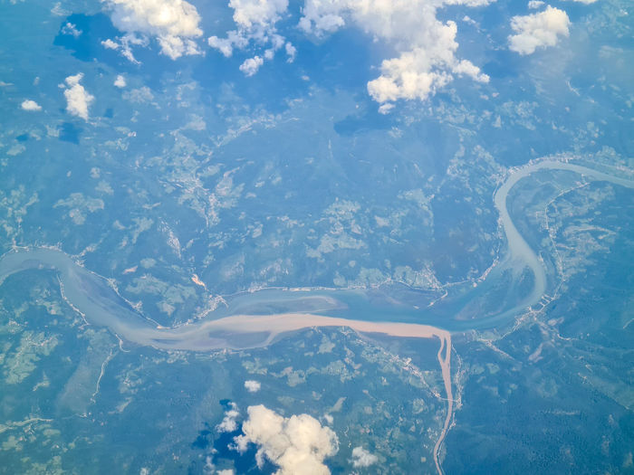 Aerial view of two rivers flowing together with clouds