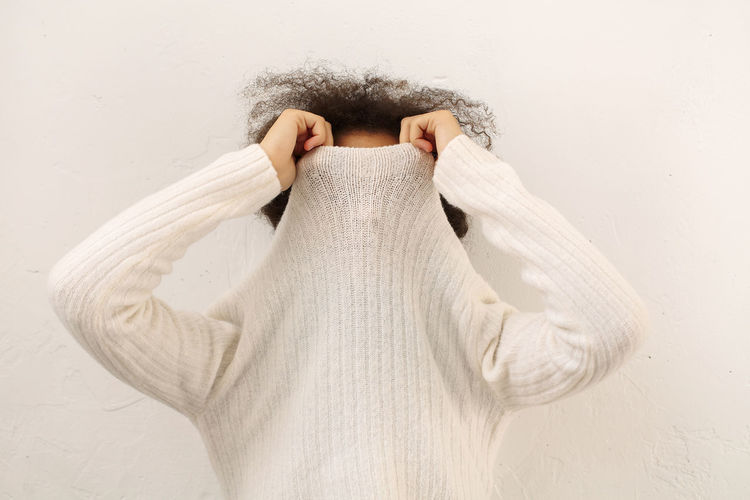 Teenager girl covering face with sweater