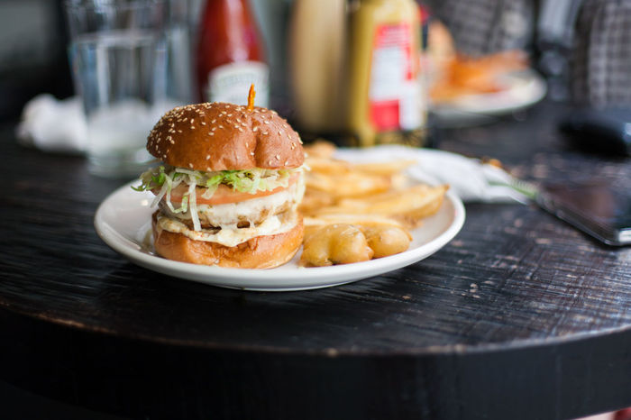 Close-up of chicken burger with french fries on plate