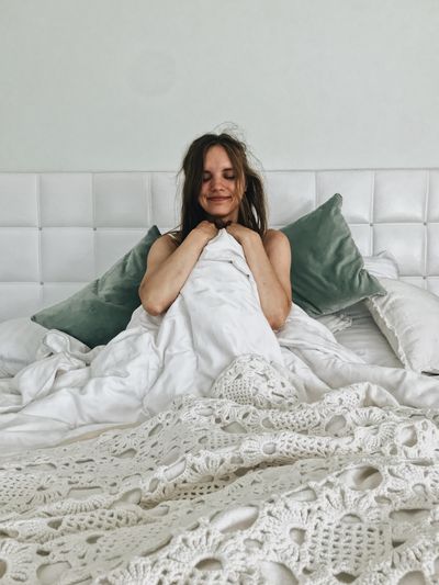Portrait of a young woman sitting on bed