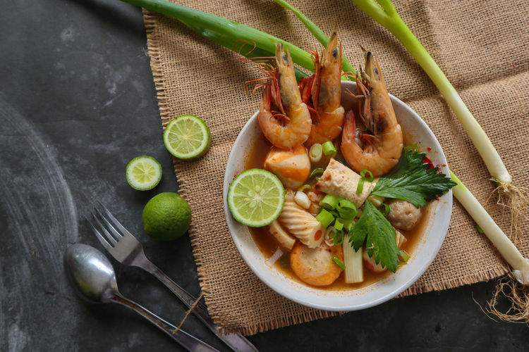 Tom yam soup originating from thailand. tom yum is made with shrimp, chili, lime, chicken, fish, 