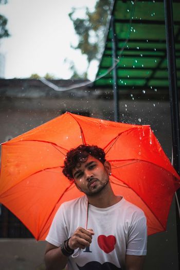 Man holding umbrella standing on rainy day