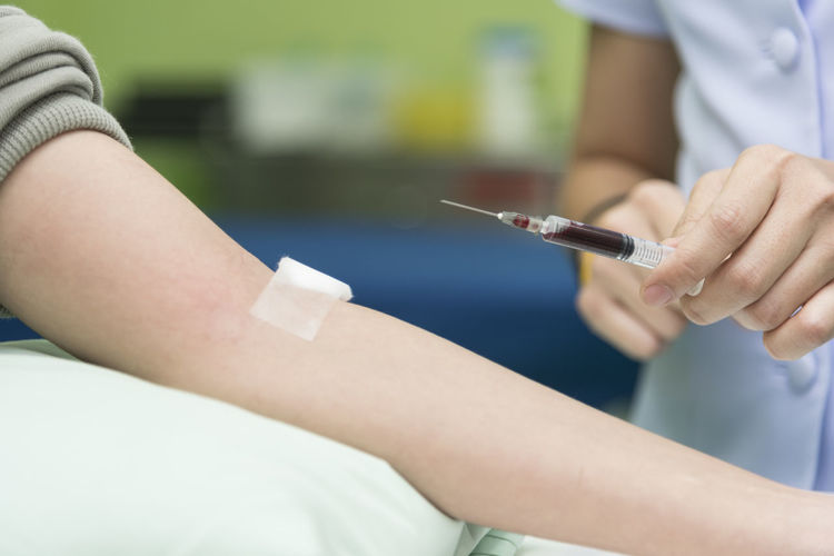 Cropped image of nurse taking blood sample of patient