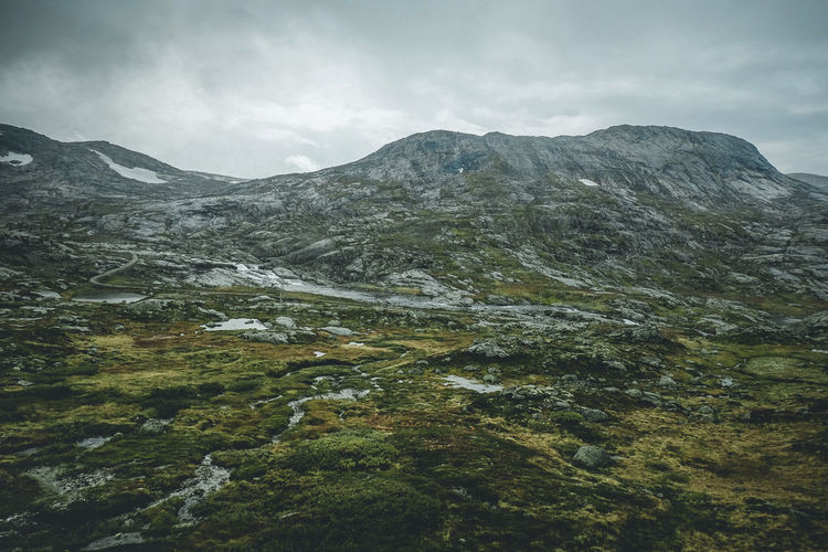 Scenic view of mountains against cloudy sky