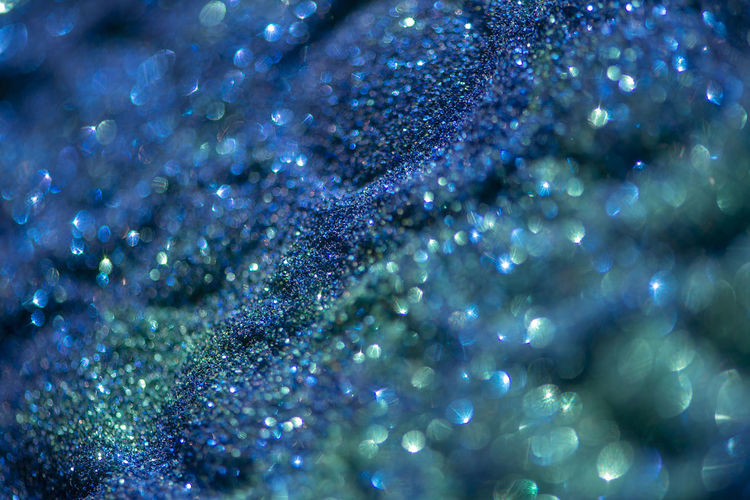 Abstract glitter lights colorful bokeh background in blue and green color tones