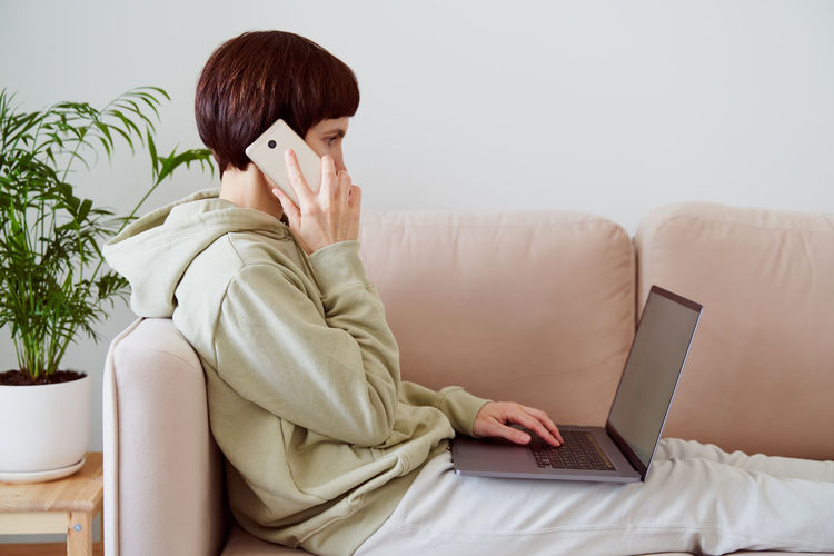 Man using mobile phone while sitting on sofa