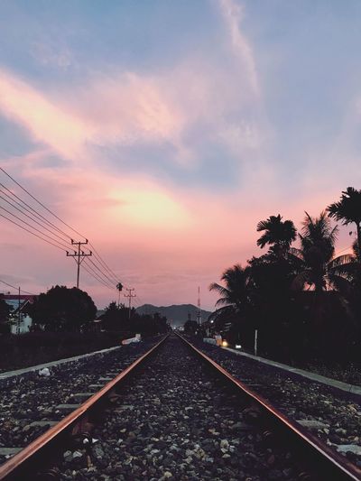 Railroad tracks against sky during sunset