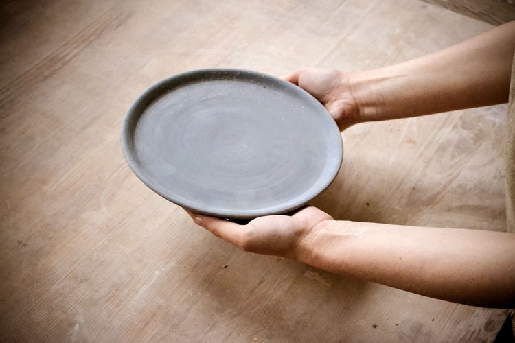 High angle view of hand holding bowl on table