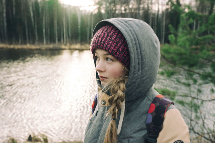 Beautiful girl in warm clothes by the river