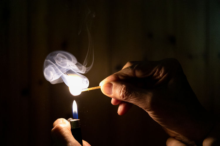 Lit match with a lighter. flame lighting a match in the dark
