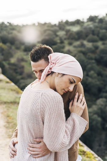 Girlfriend wearing bandana embracing boyfriend
