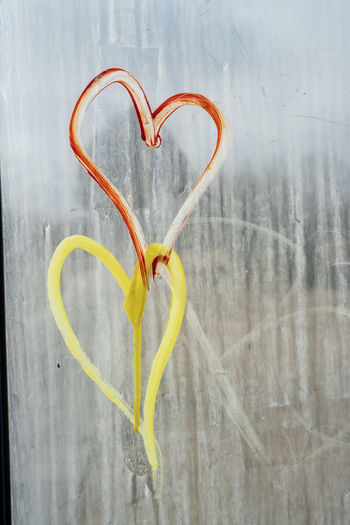 Hearts on streaky glass window of bus stop