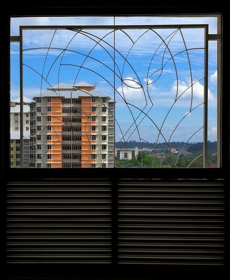 Buildings against sky seen through glass window