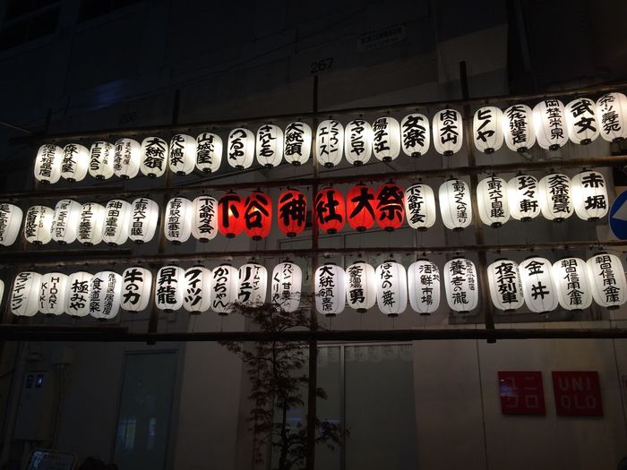 Illuminated japanese lantern hanging by building