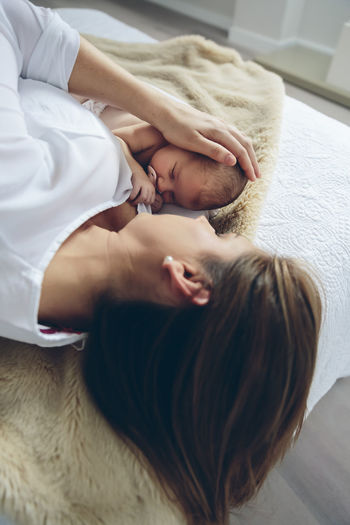 Mother with daughter lying down on bed at home