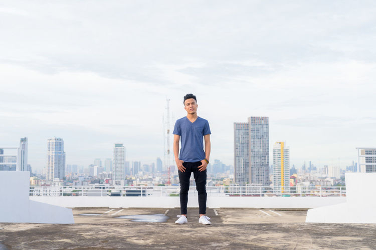 Full length of man standing on city against sky