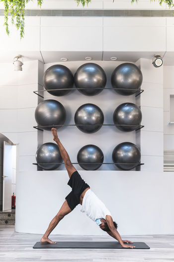 Active young man exercising yoga at health club during coronavirus