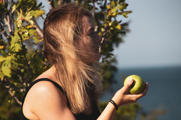 Midsection of woman holding apple
