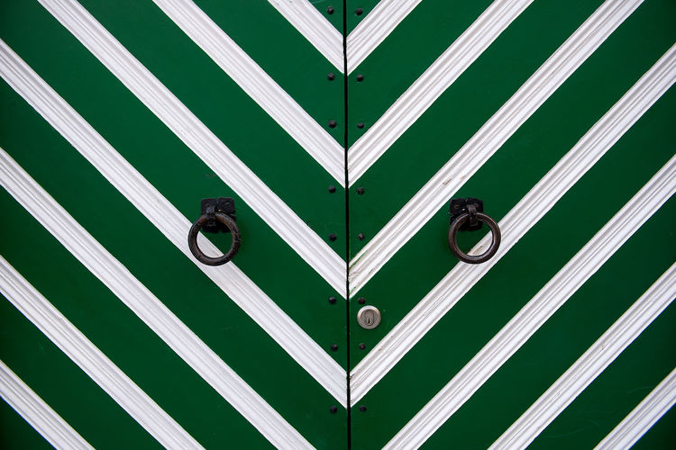Ring knockers on green door