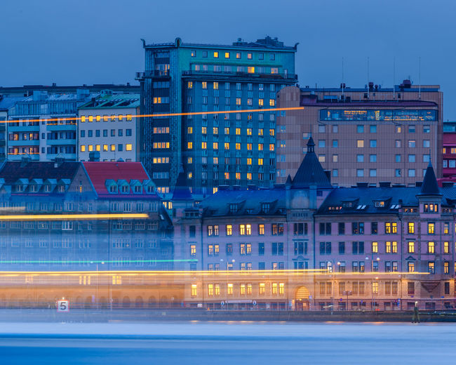 Ferry passing on river in front of cityscape