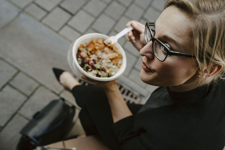 Female entrepreneur with salad bowl looking away