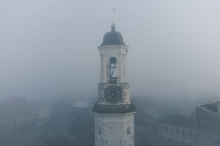 Ancient clock tower in the historical center of vyborg. foggy morning. object of cultural heritage