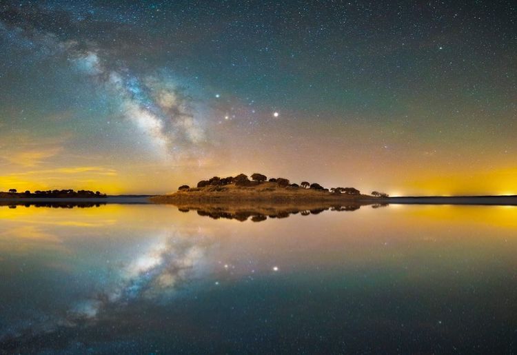 Scenic view of lake against sky at night