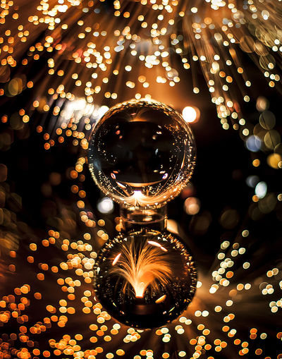 Close-up of illuminated light bulb hanging on christmas tree