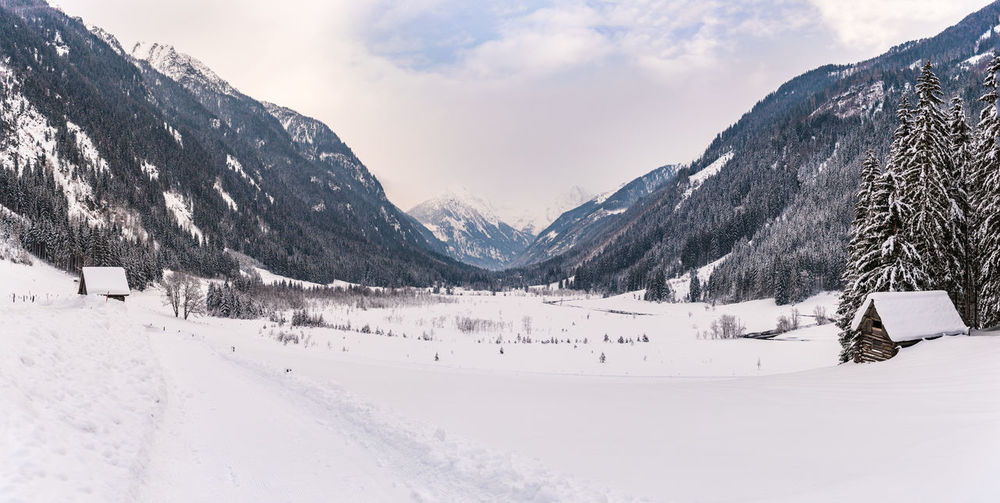Winter mountain landscape in the alps. the valley, meadow, trees and mountains covered with snow.